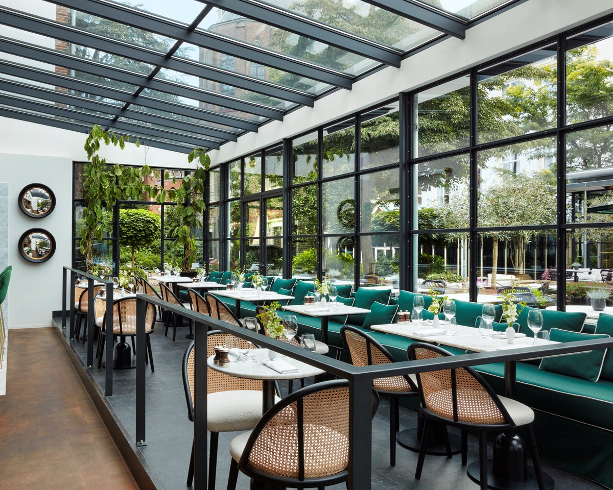 Pulitzer Garden interior in hotel Pulitzer Amsterdam restaurant seating area with big windows overlooking the garden