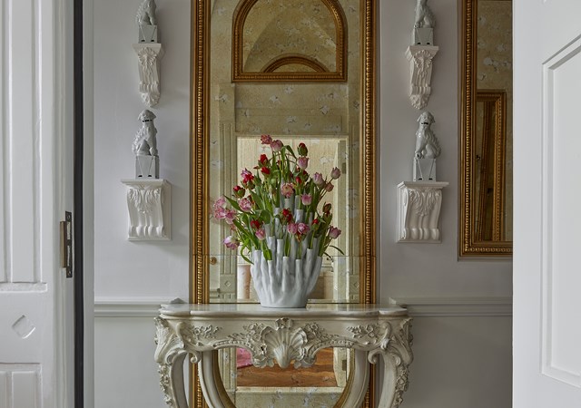 A white table adorned with a vase of vibrant flowers, creating a fresh and inviting atmosphere.