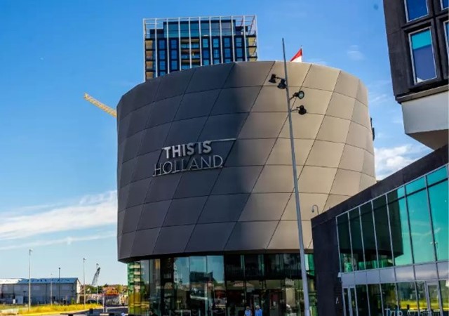 A view of a building located next to a road, highlighting its architectural features and proximity to the street.