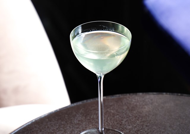 A transparent glass containing a white liquid rests on a table, showcasing its clarity and simplicity.