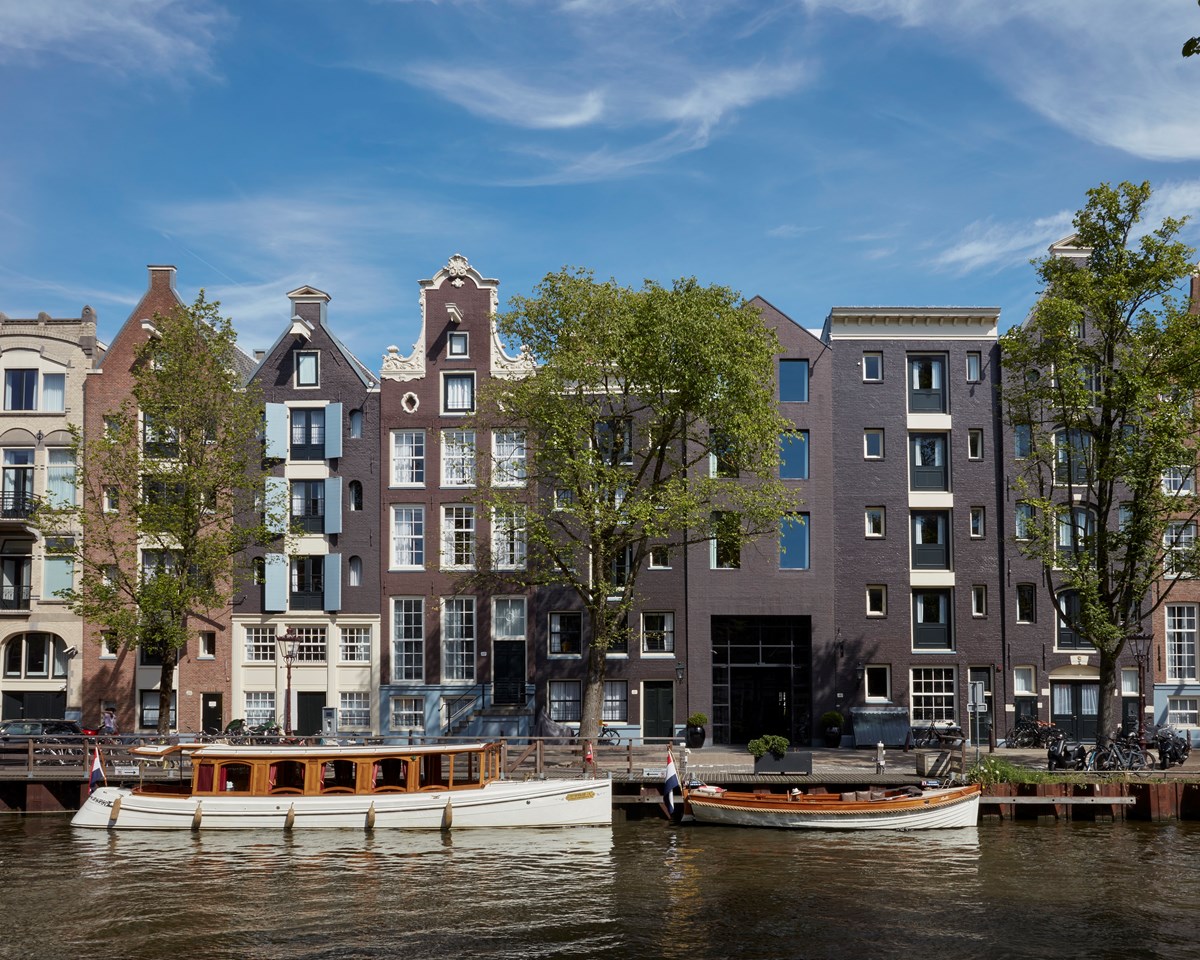 A charming scene featuring buildings along the water's edge, with several boats anchored nearby.