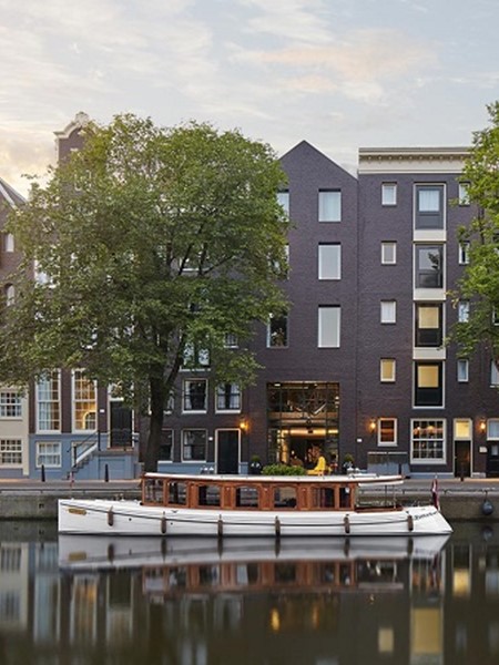 A boat rests at the dock, with a picturesque row of buildings in the background.