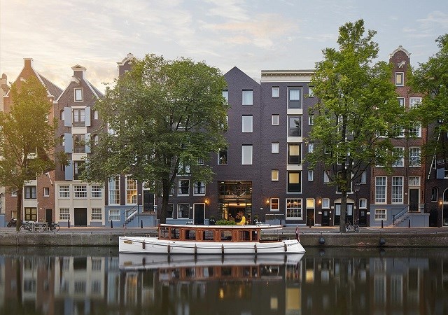 A boat rests at the dock, with a picturesque row of buildings in the background.