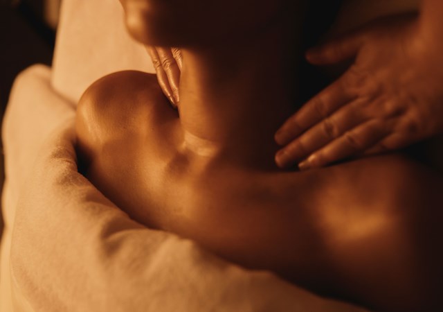 A woman enjoying a relaxing massage in a serene spa environment, promoting wellness and tranquility.