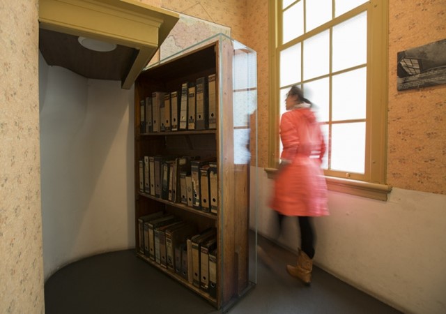 A woman walks through the bookcase at the Anne Frank House in Amsterdam.