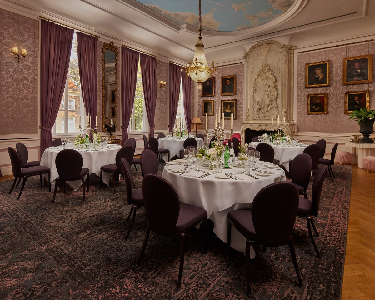 An expansive room showcasing a sizable table with multiple chairs arranged around it, ideal for discussions.