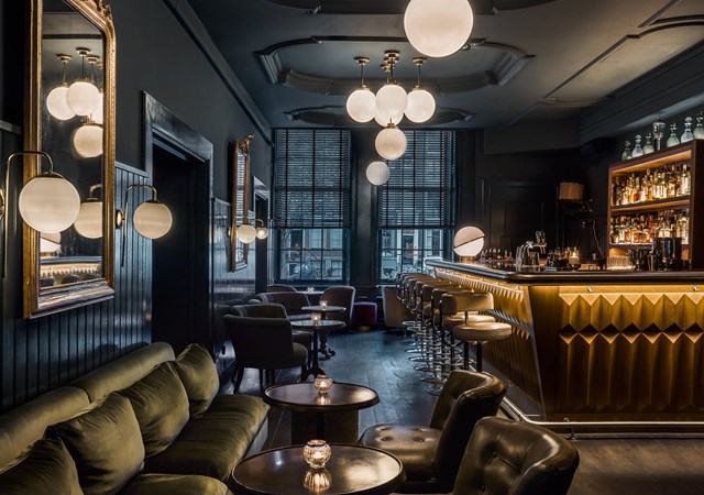 Pulitzer's bar in hotel Pulitzer Amsterdam overview of bar with chairs and white round lamps