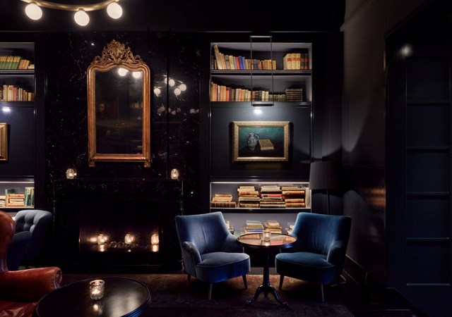 Pulitzer's bar in hotel Pulitzer Amsterdam dark corner with chairs in sitting area plus books
