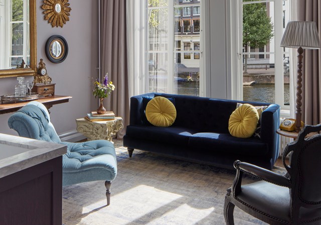 A cozy living room featuring a comfortable couch, a stylish chair, and a modern table, creating an inviting atmosphere.