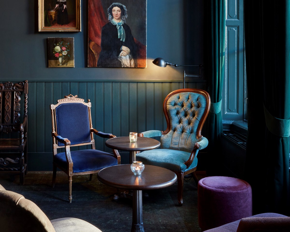Pulitzer's bar in hotel Pulitzer Amsterdam with chairs in sitting area plus paintings