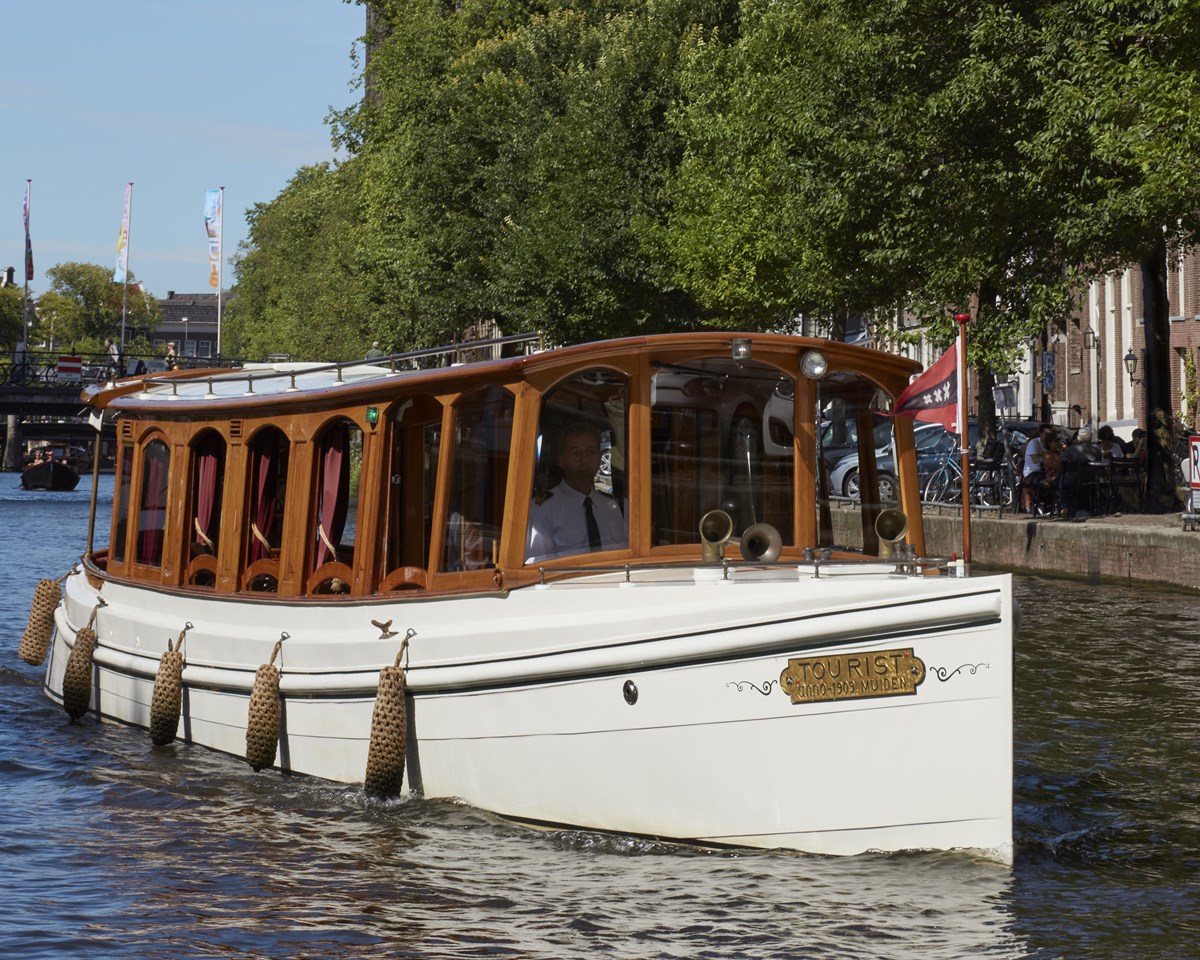A serene boat floating gently on calm water, reflecting the surrounding landscape.