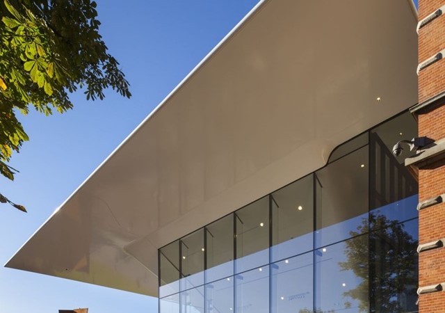 The modern building of the Stedelijk Museum featuring expansive glass walls, reflecting the surrounding environment.