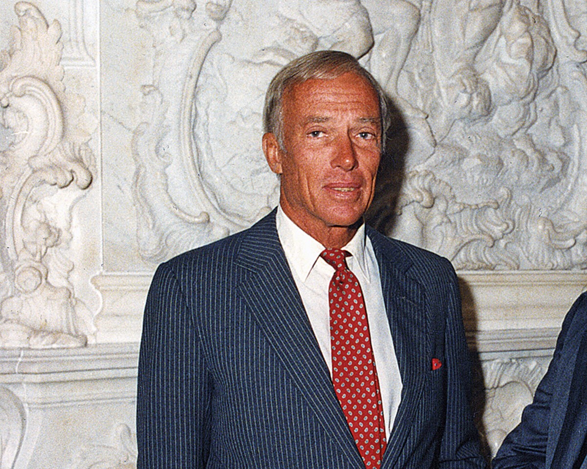 A well-dressed man in a suit and tie, representing sophistication and business acumen.