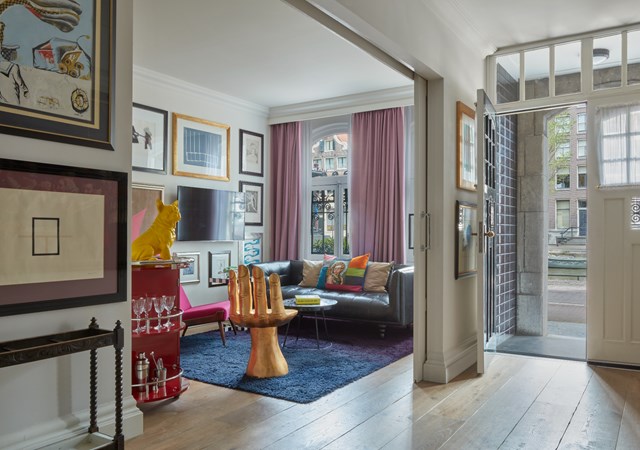 A spacious living room featuring a large picture frame prominently displayed on the wall.