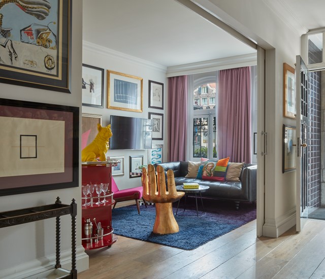 A spacious living room featuring a large picture frame prominently displayed on the wall.