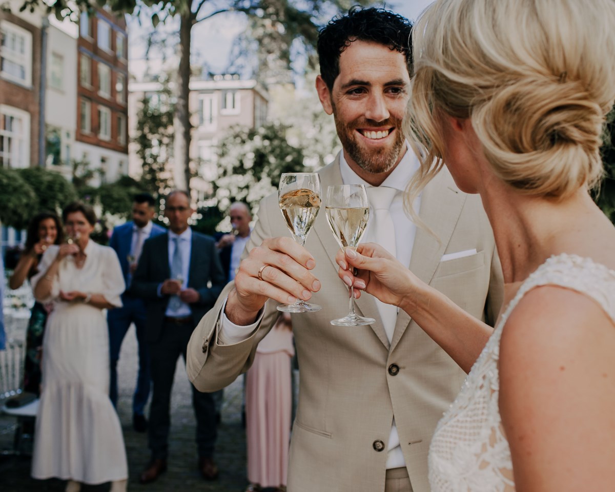 A wedding photographer, expertly captures a couple's joyful celebration in Amsterdam.